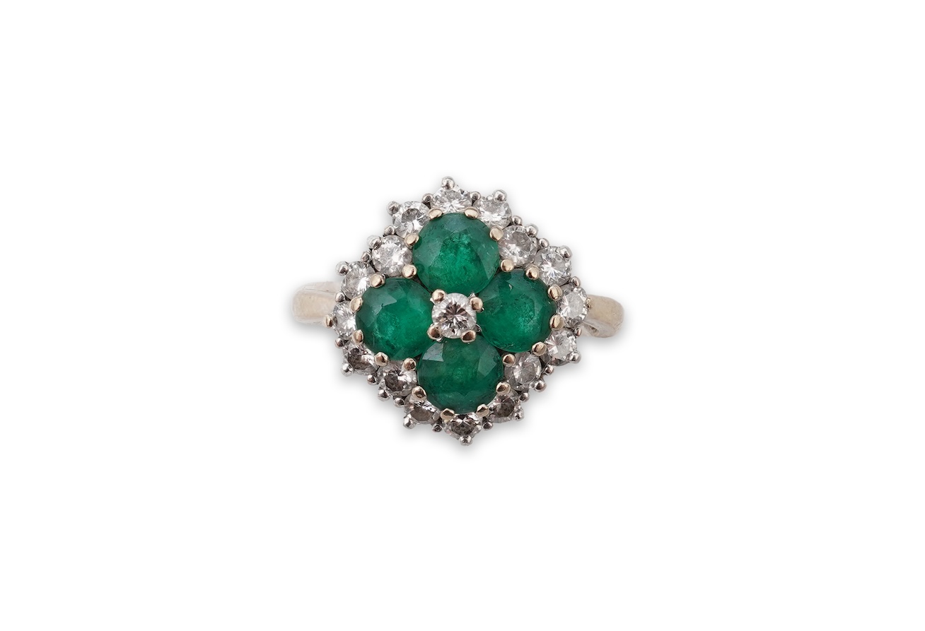 An emerald and diamond cluster ring